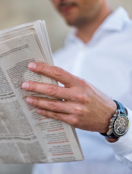 Mann in Hemd liest Zeitung